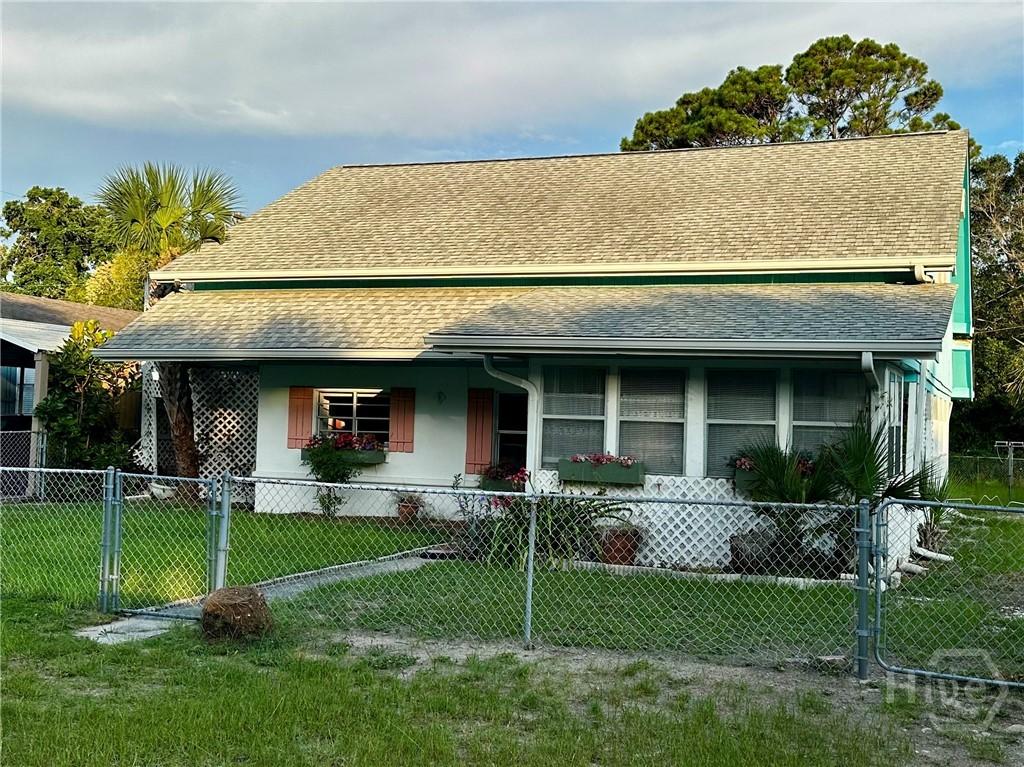9 Miller Ave, Tybee Island, GA 31328 - view of front of property with a shingled roof, a fenced front yard, and a porch