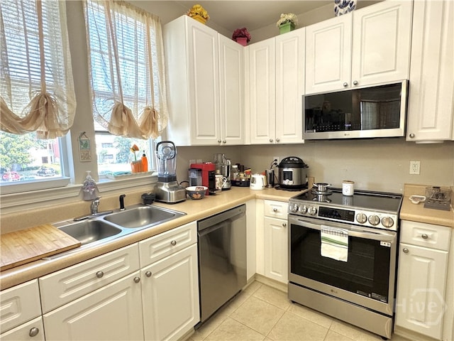 1312 Whitemarsh Way, Savannah, GA 31410 - kitchen with stainless steel appliances, white cabinets, light tile patterned floors, and light countertops