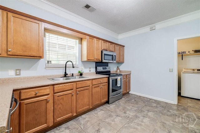 86 Fellwood Dr, Rincon, GA 31326 - kitchen with stainless steel appliances, washer / clothes dryer, crown molding, a textured ceiling, and brown cabinetry