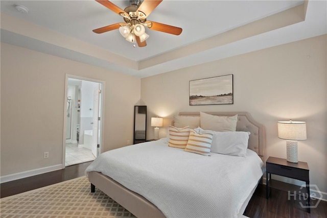 22 Carriage Way, Midway, GA 31320 - bedroom featuring a tray ceiling, wood finished floors, ensuite bath, and ceiling fan