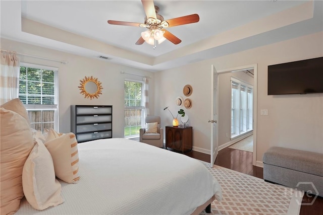 22 Carriage Way, Midway, GA 31320 - bedroom featuring wood finished floors, a tray ceiling, and ceiling fan