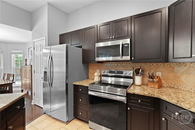 22 Carriage Way, Midway, GA 31320 - kitchen with stainless steel appliances, backsplash, light tile patterned flooring, light stone counters, and dark brown cabinetry