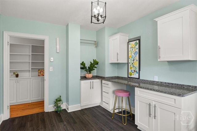 540 E 60th St, Savannah, GA 31405 - kitchen with dark wood finished floors, white cabinets, dark stone counters, a chandelier, and hanging light fixtures