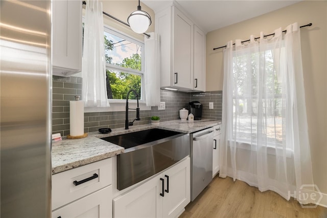 402 E 57th St, Savannah, GA 31405 - kitchen with stainless steel appliances, tasteful backsplash, light wood-style floors, white cabinets, and light stone counters