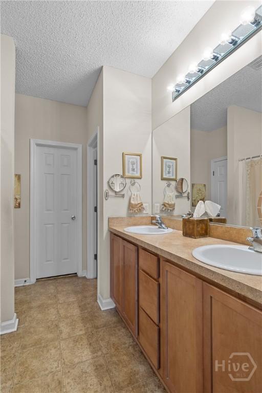 19 Travertine Cir, Savannah, GA 31419 - full bath featuring double vanity, a textured ceiling, tile patterned floors, and a shower with shower curtain