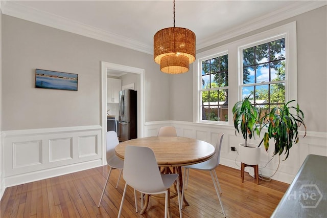 1406 E 50th St, Savannah, GA 31404 - dining area featuring a chandelier, a decorative wall, wainscoting, wood finished floors, and ornamental molding