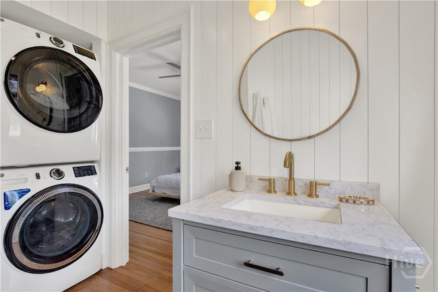 1406 E 50th St, Savannah, GA 31404 - laundry area with stacked washer / dryer, crown molding, and wood finished floors