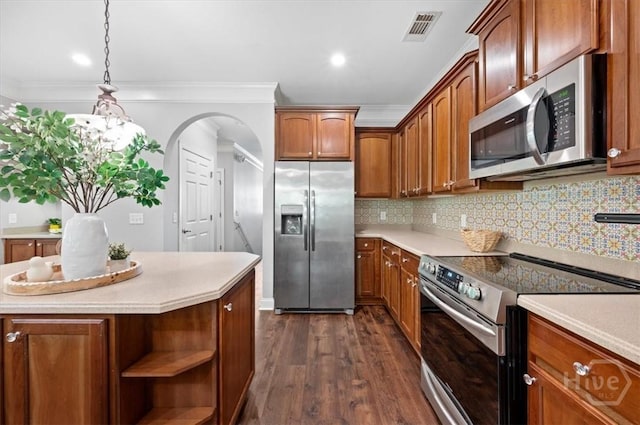 2604 River Oaks Dr Unit 2604, Richmond Hill, GA 31324 - kitchen with stainless steel appliances, dark wood finished floors, light countertops, brown cabinetry, and ornamental molding