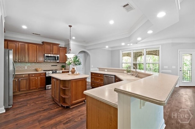 2604 River Oaks Dr Unit 2604, Richmond Hill, GA 31324 - kitchen featuring stainless steel appliances, a large island, arched walkways, dark wood finished floors, and ornamental molding