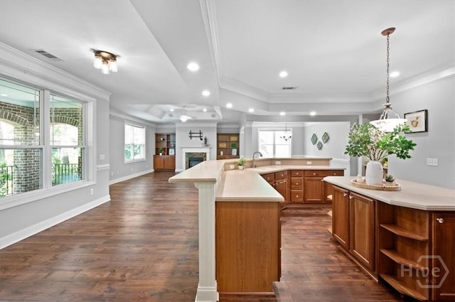 2604 River Oaks Dr Unit 2604, Richmond Hill, GA 31324 - kitchen with open floor plan, a large island with sink, light countertops, ornamental molding, and dark wood-style flooring