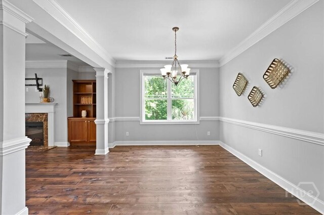2604 River Oaks Dr Unit 2604, Richmond Hill, GA 31324 - unfurnished dining area featuring dark wood-style flooring, a chandelier, ornate columns, a high end fireplace, and ornamental molding