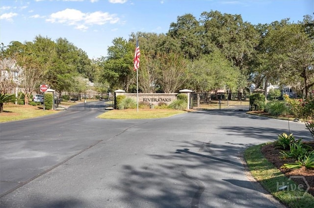 2604 River Oaks Dr Unit 2604, Richmond Hill, GA 31324 - view of asphalt street with a gate, traffic signs, and a gated entry