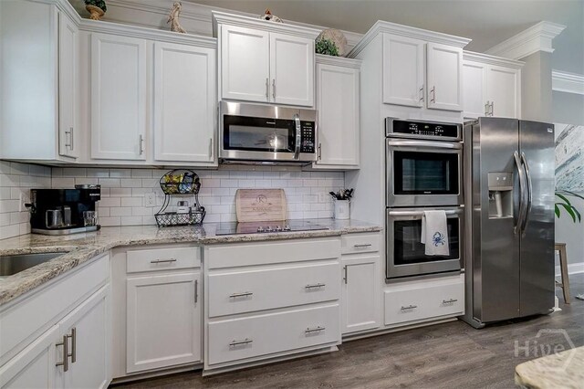1652 Belle Island Rd, Richmond Hill, GA 31324 - kitchen with stainless steel appliances, white cabinetry, dark wood finished floors, tasteful backsplash, and light stone counters