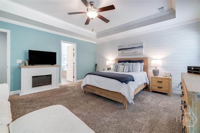 1652 Belle Island Rd, Richmond Hill, GA 31324 - bedroom with light colored carpet, a tray ceiling, a glass covered fireplace, ornamental molding, and ceiling fan