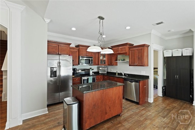1226 Peacock Trl, Hinesville, GA 31313 - kitchen featuring appliances with stainless steel finishes, dark wood finished floors, crown molding, a kitchen island, and pendant lighting