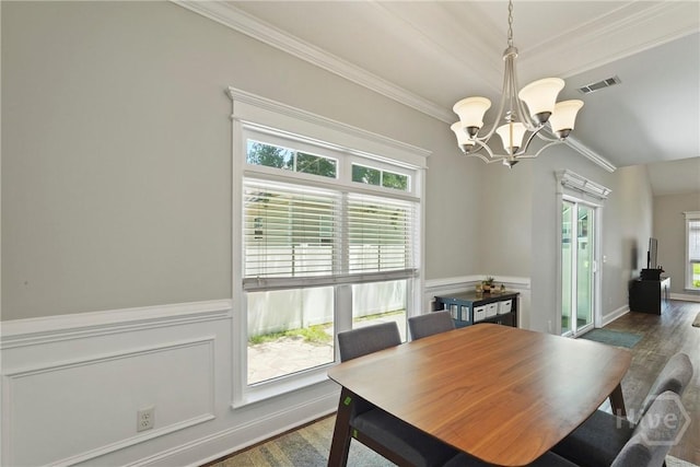 1226 Peacock Trl, Hinesville, GA 31313 - dining area featuring a chandelier, ornamental molding, wood finished floors, and wainscoting