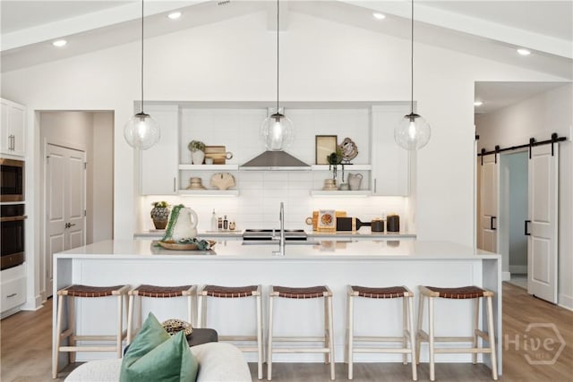 117 Mage St, Savannah, GA 31302 - kitchen featuring open shelves, lofted ceiling, a barn door, tasteful backsplash, and light countertops