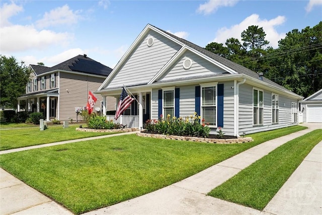25 Savannah Ln, Richmond Hill, GA 31324 - view of front of property featuring covered porch, a front lawn, driveway, a detached garage, and an outdoor structure