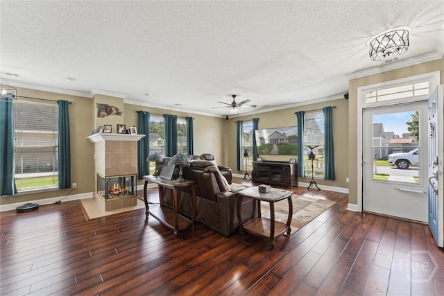 25 Savannah Ln, Richmond Hill, GA 31324 - living area with a tile fireplace, a textured ceiling, ornamental molding, dark wood-style floors, and ceiling fan