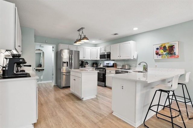 144 Summer Winds Dr, Savannah, GA 31410 - kitchen with stainless steel appliances, a peninsula, light wood-type flooring, recessed lighting, and a center island