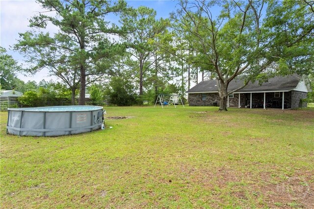 65 Fabian Ln, Hinesville, GA 31313 - view of grassy yard with a playground and an outdoor pool