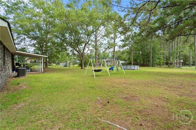 65 Fabian Ln, Hinesville, GA 31313 - view of green lawn featuring a playground