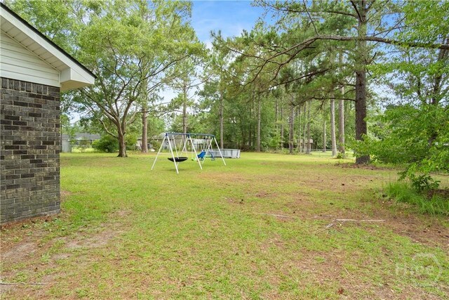 65 Fabian Ln, Hinesville, GA 31313 - view of green lawn featuring a playground