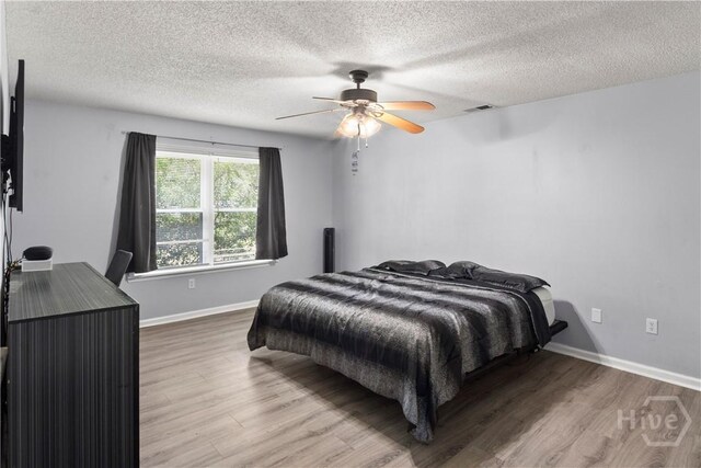 65 Fabian Ln, Hinesville, GA 31313 - bedroom featuring wood finished floors, a textured ceiling, and a ceiling fan