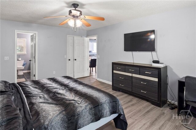 65 Fabian Ln, Hinesville, GA 31313 - bedroom featuring light wood-type flooring, connected bathroom, a ceiling fan, and a textured ceiling