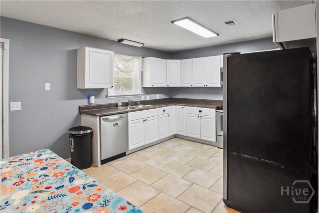 65 Fabian Ln, Hinesville, GA 31313 - kitchen featuring stainless steel appliances, white cabinetry, a textured ceiling, dark countertops, and light tile patterned flooring