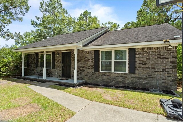 65 Fabian Ln, Hinesville, GA 31313 - single story home featuring covered porch, a front yard, brick siding, and a shingled roof
