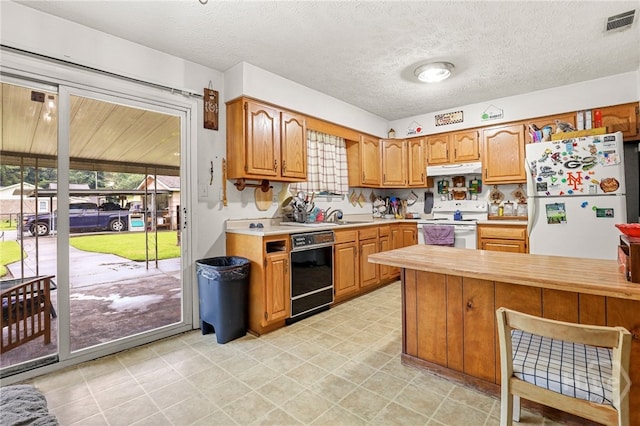 101 Greene Dr, Rincon, GA 31326 - kitchen featuring white appliances, light countertops, healthy amount of natural light, under cabinet range hood, and a textured ceiling