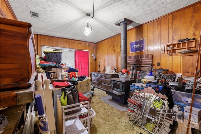 101 Greene Dr, Rincon, GA 31326 - misc room with a wood stove, carpet, wooden walls, and a textured ceiling