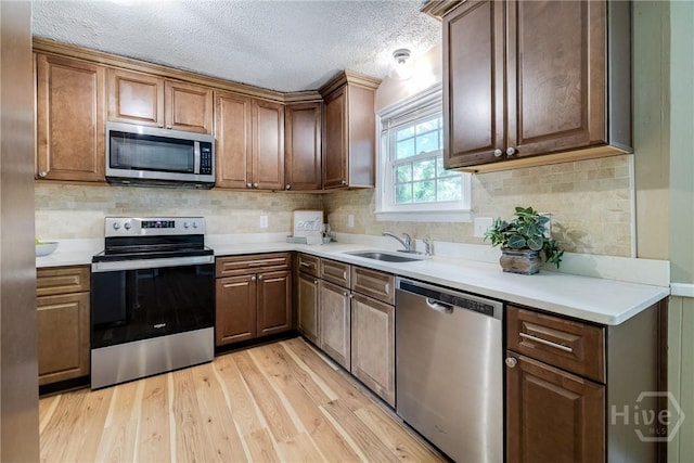 322 Suncrest Blvd, Savannah, GA 31410 - kitchen featuring stainless steel appliances, light wood-style flooring, light countertops, backsplash, and a textured ceiling