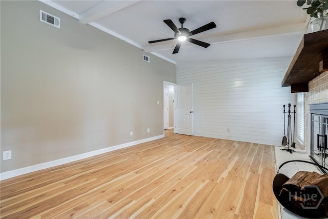 322 Suncrest Blvd, Savannah, GA 31410 - unfurnished living room with light wood-type flooring, a brick fireplace, a ceiling fan, and wood walls