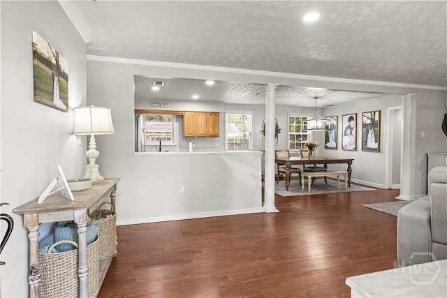 1001 Debbie St, Savannah, GA 31410 - living area featuring dark wood finished floors, a textured ceiling, crown molding, and ornate columns