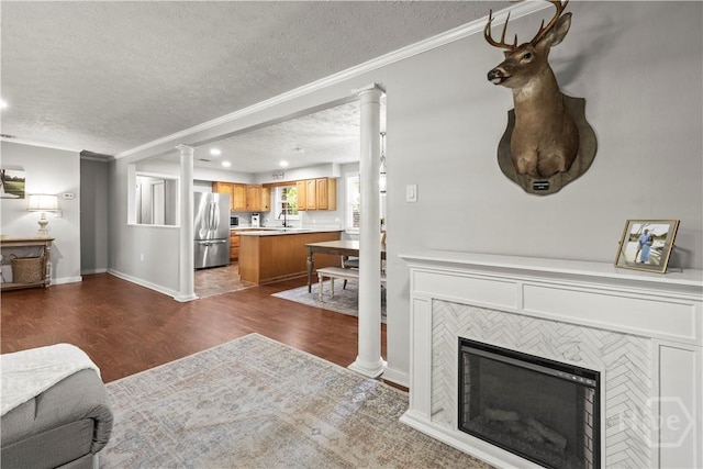 1001 Debbie St, Savannah, GA 31410 - living area with a textured ceiling, decorative columns, dark wood-style flooring, a fireplace, and ornamental molding