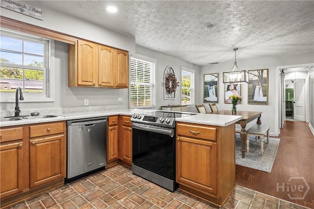 1001 Debbie St, Savannah, GA 31410 - kitchen featuring appliances with stainless steel finishes, a peninsula, light countertops, a textured ceiling, and decorative light fixtures