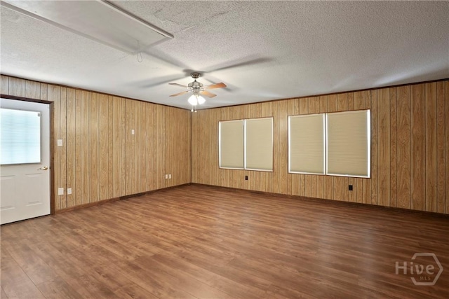 13609 Rockingham Ct, Savannah, GA 31419 - spare room with attic access, wood finished floors, wood walls, ceiling fan, and a textured ceiling