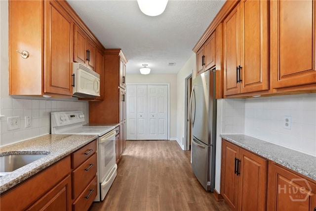 13609 Rockingham Ct, Savannah, GA 31419 - kitchen with white appliances, brown cabinets, and dark wood-style floors