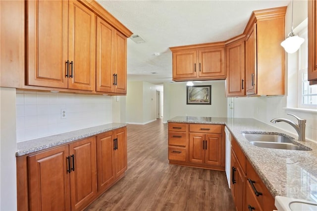 13609 Rockingham Ct, Savannah, GA 31419 - kitchen featuring brown cabinets, wood finished floors, and backsplash