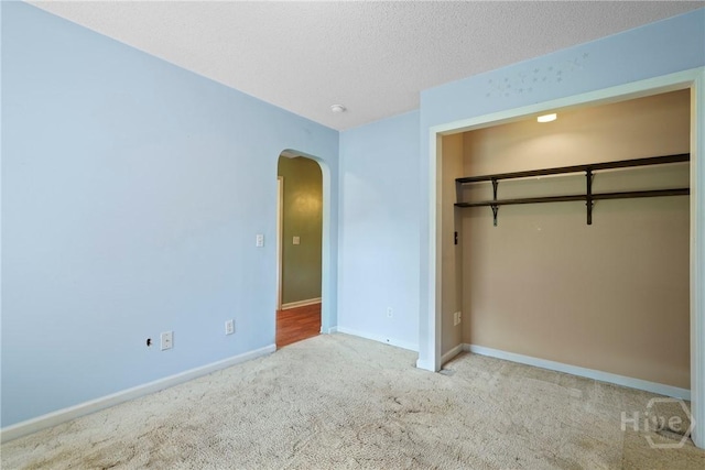 11 Gilliam Ave, Savannah, GA 31406 - unfurnished bedroom with arched walkways, carpet flooring, a closet, and a textured ceiling