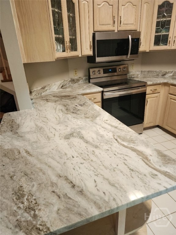 123 Companion Way, Savannah, GA 31419 - kitchen featuring stainless steel appliances, light stone counters, light tile patterned floors, and light brown cabinetry
