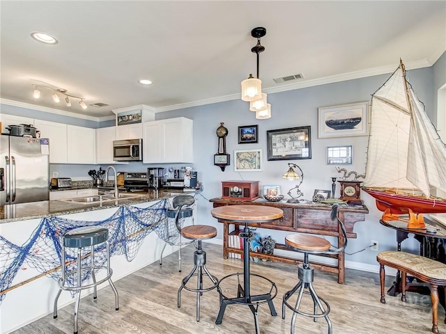 8 Silver Ave Unit 9, Tybee Island, GA 31328 - dining area featuring crown molding and light wood-style flooring