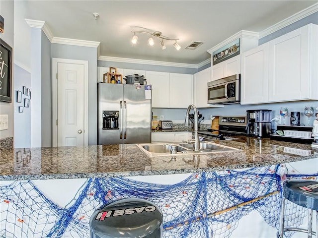 8 Silver Ave Unit 9, Tybee Island, GA 31328 - kitchen featuring appliances with stainless steel finishes, white cabinets, a peninsula, and ornamental molding