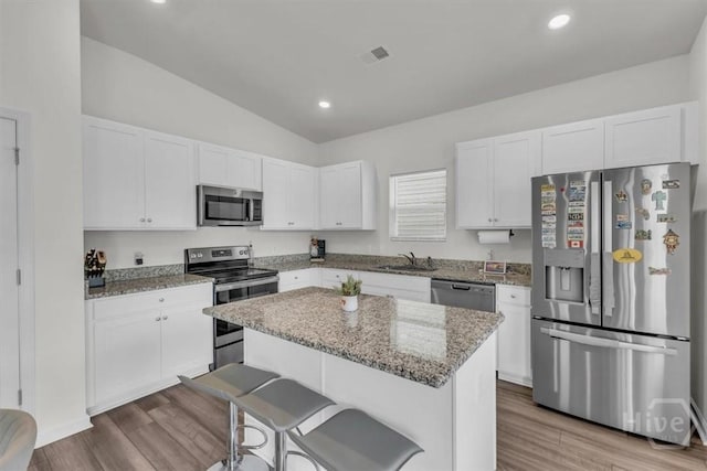 105 Jepson Way, Pooler, GA 31322 - kitchen featuring appliances with stainless steel finishes, white cabinets, a center island, light stone countertops, and a kitchen bar