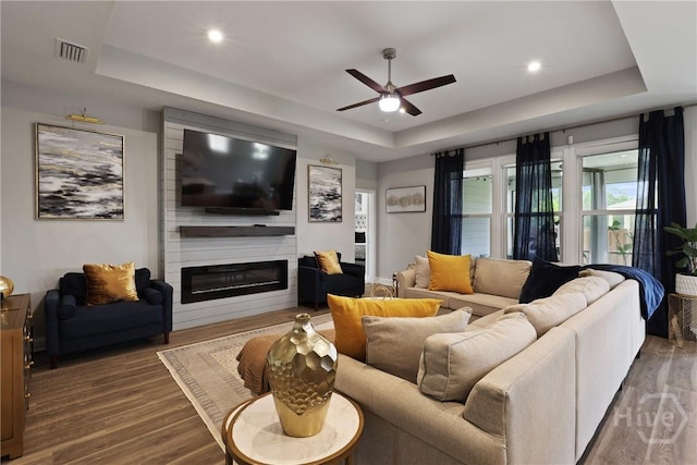 742 Longleaf Dr, Richmond Hill, GA 31324 - living area featuring a tray ceiling, a ceiling fan, wood finished floors, a fireplace, and recessed lighting