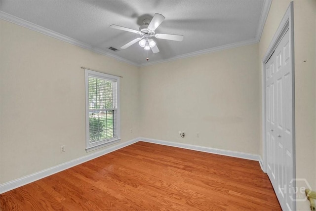 80 Windsong Dr, Richmond Hill, GA 31324 - unfurnished bedroom with wood finished floors, a closet, crown molding, ceiling fan, and a textured ceiling