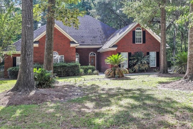 80 Windsong Dr, Richmond Hill, GA 31324 - traditional home with a front yard, brick siding, and roof with shingles