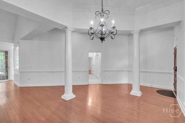 80 Windsong Dr, Richmond Hill, GA 31324 - unfurnished dining area featuring decorative columns, wood finished floors, a chandelier, and ornamental molding